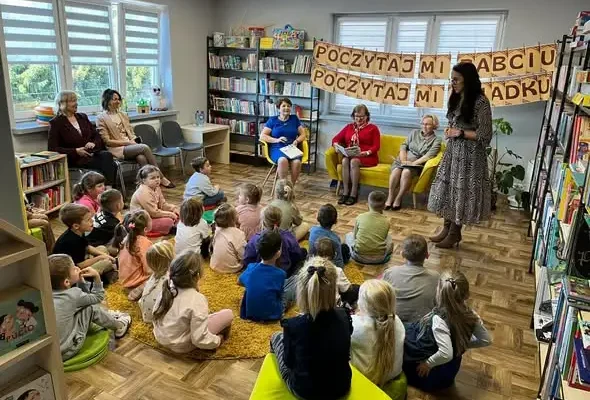 Międzypokoleniowe czytanie w bibliotece w Ruscu z okazji Dnia Osób Starszych